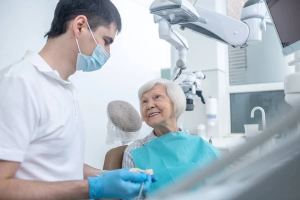 Dentista do sexo masculino conversando com seu paciente senipr e explicando seu diagnóstico — Fotografia de Stock