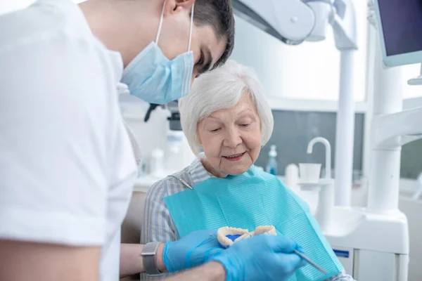 Dentista do sexo masculino conversando com seu paciente senipr e explicando seu diagnóstico — Fotografia de Stock