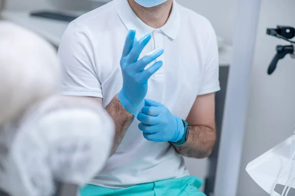Nahaufnahme eines Arztes, der sterile Handschuhe anzieht — Stockfoto