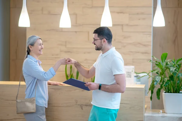 Mature good-looking woman talking to the doctor at the reception and looking involved — Φωτογραφία Αρχείου