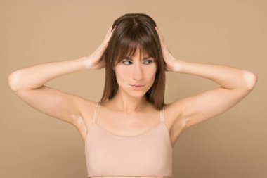 Uzun saçlı, deri pigmentasyonu kulaklarını kapatan genç bir kadın.