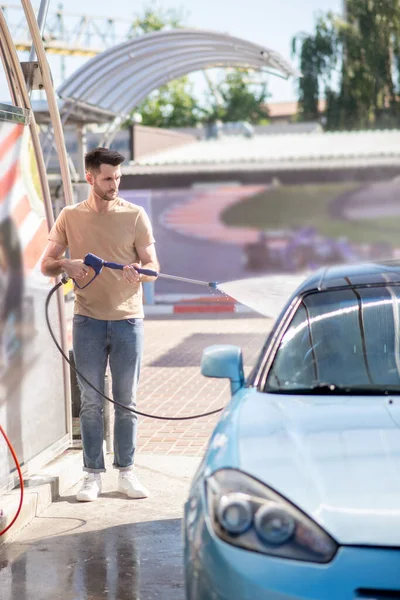 Joven adulto hombre sirviendo automóvil en lavado de coches — Foto de Stock