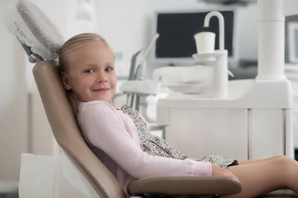 치과 의자에 앉아 있는 귀여운 금발 소녀 — 스톡 사진