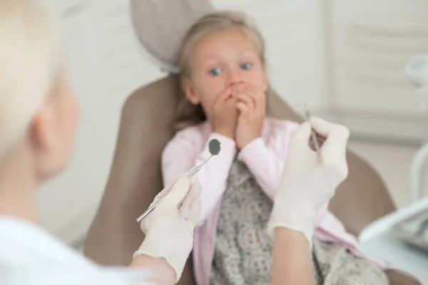 Uma menina visitando dentista e se sentindo animado — Fotografia de Stock