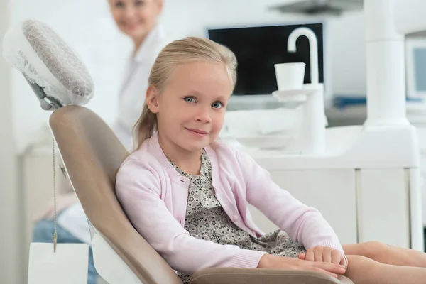 Uma menina visitando dentista e se sentindo animado — Fotografia de Stock