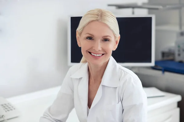 Eine gut aussehende Ärztin lächelt freundlich — Stockfoto