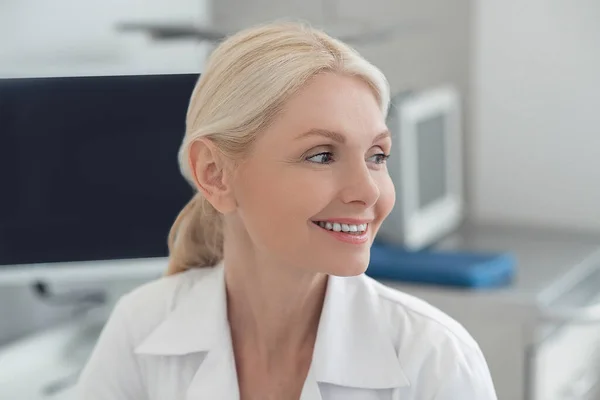 Una doctora guapa sonriendo amablemente — Foto de Stock