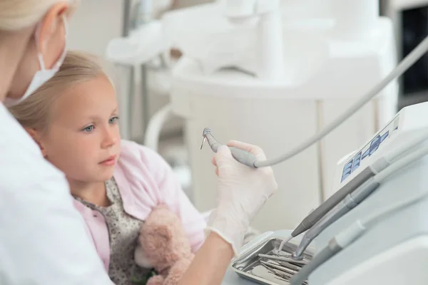 Una niña rubia recibiendo tratamiento dental en los dentistas —  Fotos de Stock