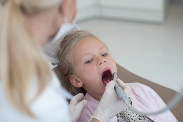 Um médico loiro segurando uma broca dentária e pronto para trabalhar — Fotografia de Stock