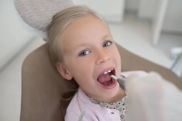 Kleiner Junge sitzt mit offenem Mund beim Zahnarzt — Stockfoto
