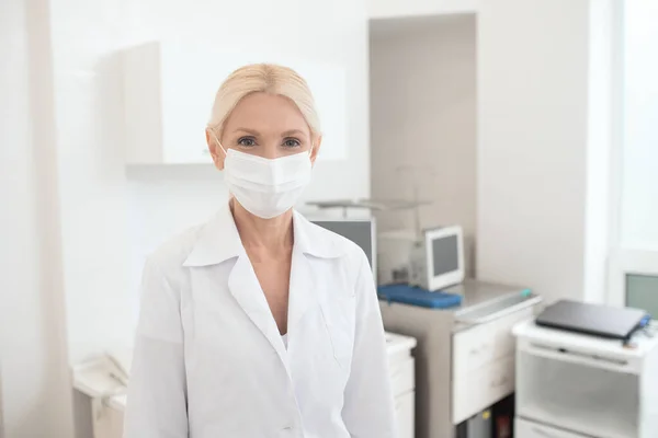 Eine blonde Ärztin mit Schutzmaske — Stockfoto