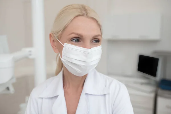 Eine blonde Ärztin mit Schutzmaske — Stockfoto