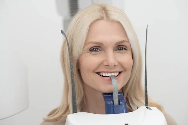 A blonde woman having dental treatment and feeling positive — Foto Stock