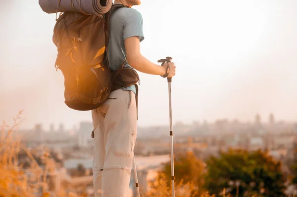 Sırt çantalı uzun bir adam tepenin üstünde duruyor. — Stok fotoğraf