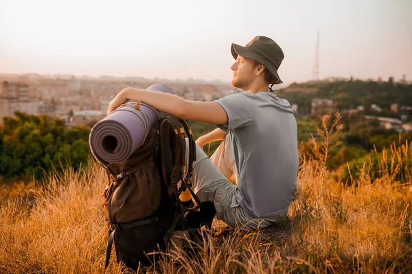 Un caminante masculino sentado en la colina y relajado — Foto de Stock