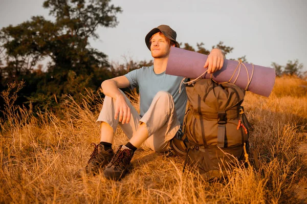 A male hiker sitting on the hill and relaxing — Stock Photo, Image