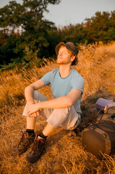 Ein junger Mann sitzt und genießt die Sonnenstrahlen — Stockfoto