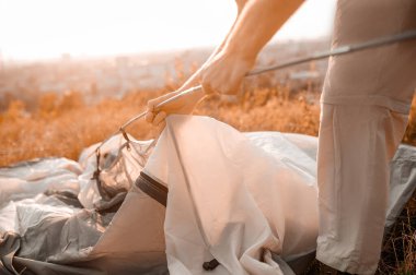 Tepede çadır kuran genç bir adam.