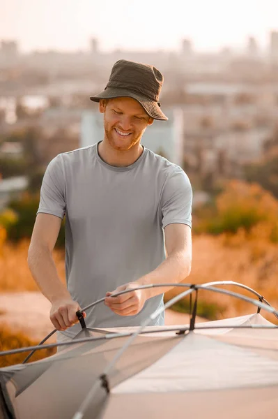 Ein Bild von einem jungen Mann, der mit dem Zeltaufbau beschäftigt ist — Stockfoto