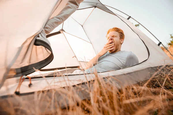 Bir adam çadırında uzanıyor ve uykulu hissediyor.