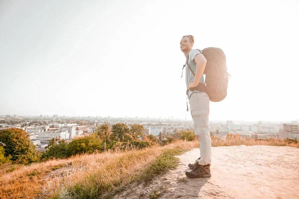 Un hombre con una mochila haciendo senderismo en un campo — Foto de Stock