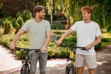 Neşeli bir adam ve arkadaşı yerel bir parkta duruyorlar.