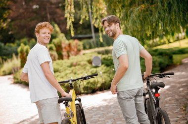 Bisikletli iki genç bir şeye bakıyor.