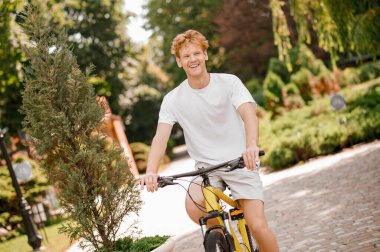 Aktif genç adam bisiklet egzersizinde eğleniyor.