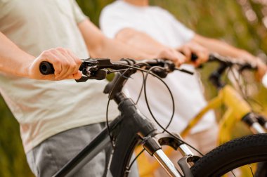 Bisikletleri açık havada gezen atletik beyaz adamlar.