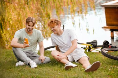 İki gülen dost cep telefonu ekranına bakıyor.