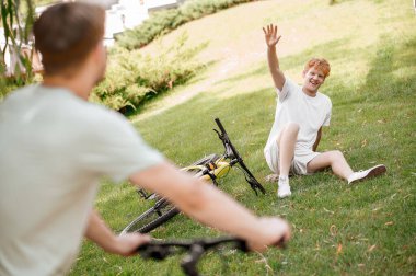 Neşeli genç adam erkek motorcuya el sallıyor.