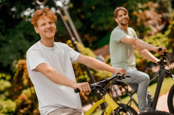 Jóvenes deportistas en bicicleta en un parque — Foto de Stock