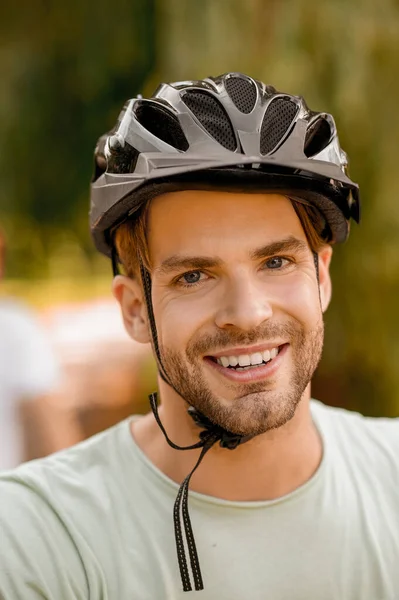 笑顔の内容のスポーツマンは屋外で自転車のヘルメットを着て — ストック写真