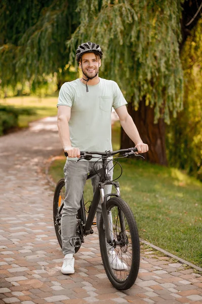 Un atractivo ciclista sonriente en un parque local — Foto de Stock