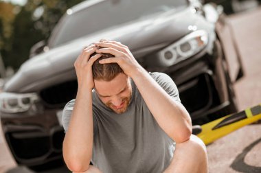 Elleriyle başını tutan umutsuz bir adam.