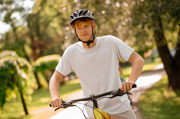 Chico en casco en bicicleta en el parque — Foto de Stock