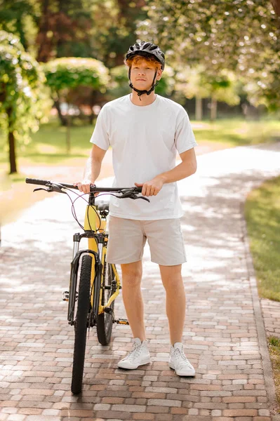 Tipo en casco con bicicleta de pie en el parque — Foto de Stock