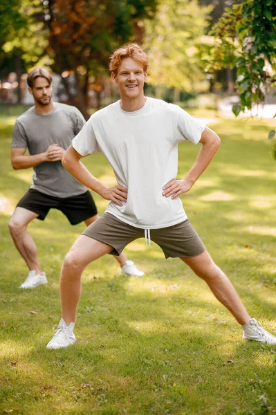 Spor egzersizleri yapan gülümseyen adamlar. — Stok fotoğraf