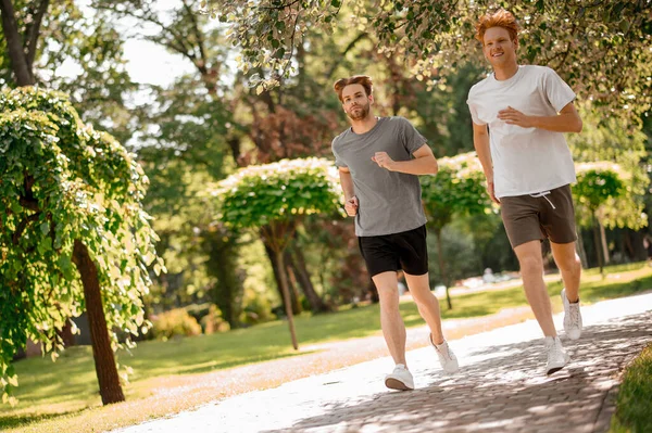 녹색 공원에서 뛰고 있는 쾌활 한 남자들 — 스톡 사진