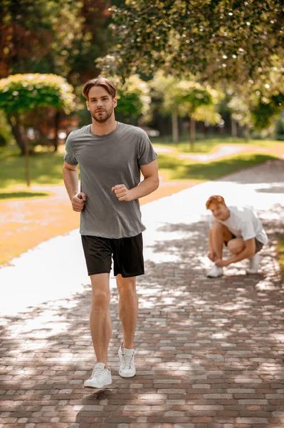 Koşan adam maratonu koşucusu ve başıboş arkadaşı — Stok fotoğraf