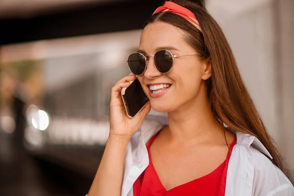 Una mujer elegante hablando por teléfono y sonriendo — Foto de Stock