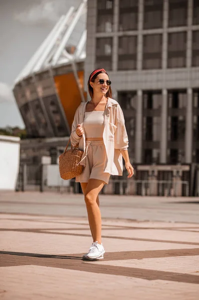 Een jonge mooie vrouw in beige kleren op straat — Stockfoto