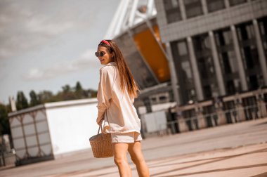 Sokakta bej elbiseli güzel bir kadın.