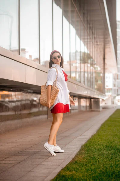 Een stijlvolle vrouw in een rode jurk op straat — Stockfoto