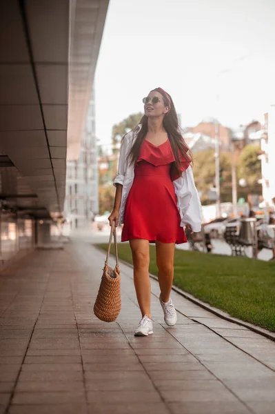 Een stijlvolle vrouw in een rode jurk op straat — Stockfoto