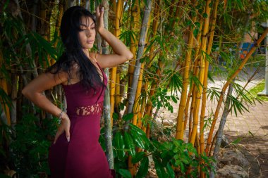 Bambu koruluğundaki düşünceli kadın baharda parka bakıyor.