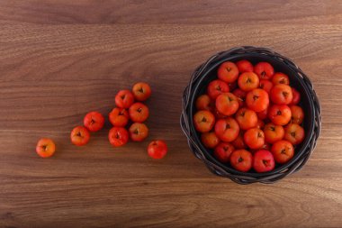 Acerolas çiğ formda ve ahşap masanın üzerine düşmüş..