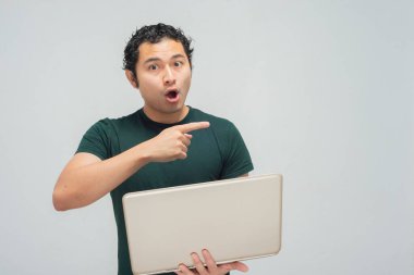 Laptoplu yeşil tişörtlü genç İspanyol Meksikalı.