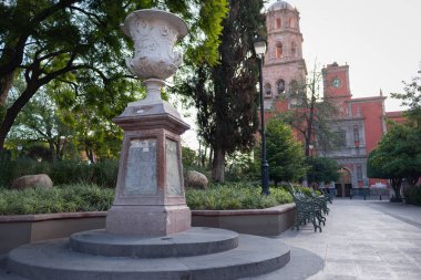 Santiago de Queretaro, Queretaro, Meksika, 07: 28. 28. Sabah zenea bahçesinde kupa heykeli. Arka planda San Francisco de Asis tapınağı, Queretaro şehir merkezinde.