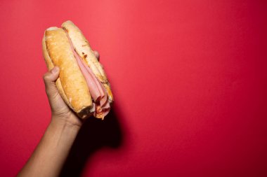 Bir el jambonlu pasta, Meksika pastası, Meksika yemeği, Meksika sandviçi, chiruzo, jambon, pan bolillo, Fransız ekmeği, kırmızı arka planlı Meksika ekmeği